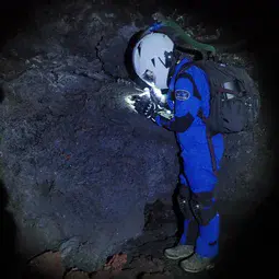 HI-SEAS crewmember exploring Mauna Loa's lava tubes as analogs for lava tubes on Mars and the moon.