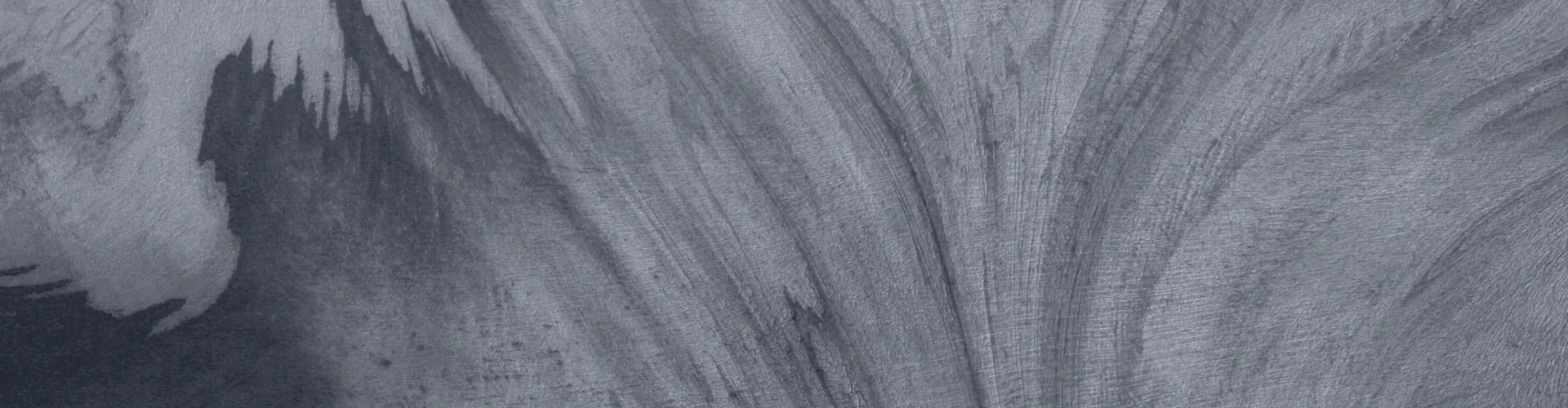 Tinted detail of a photo: Aerial view of a glacier surface in pale blue and white, its ice streaked with dark curving bands that sweep and swirl like marbled paper, with a deep blue shadowed area at lower left.
